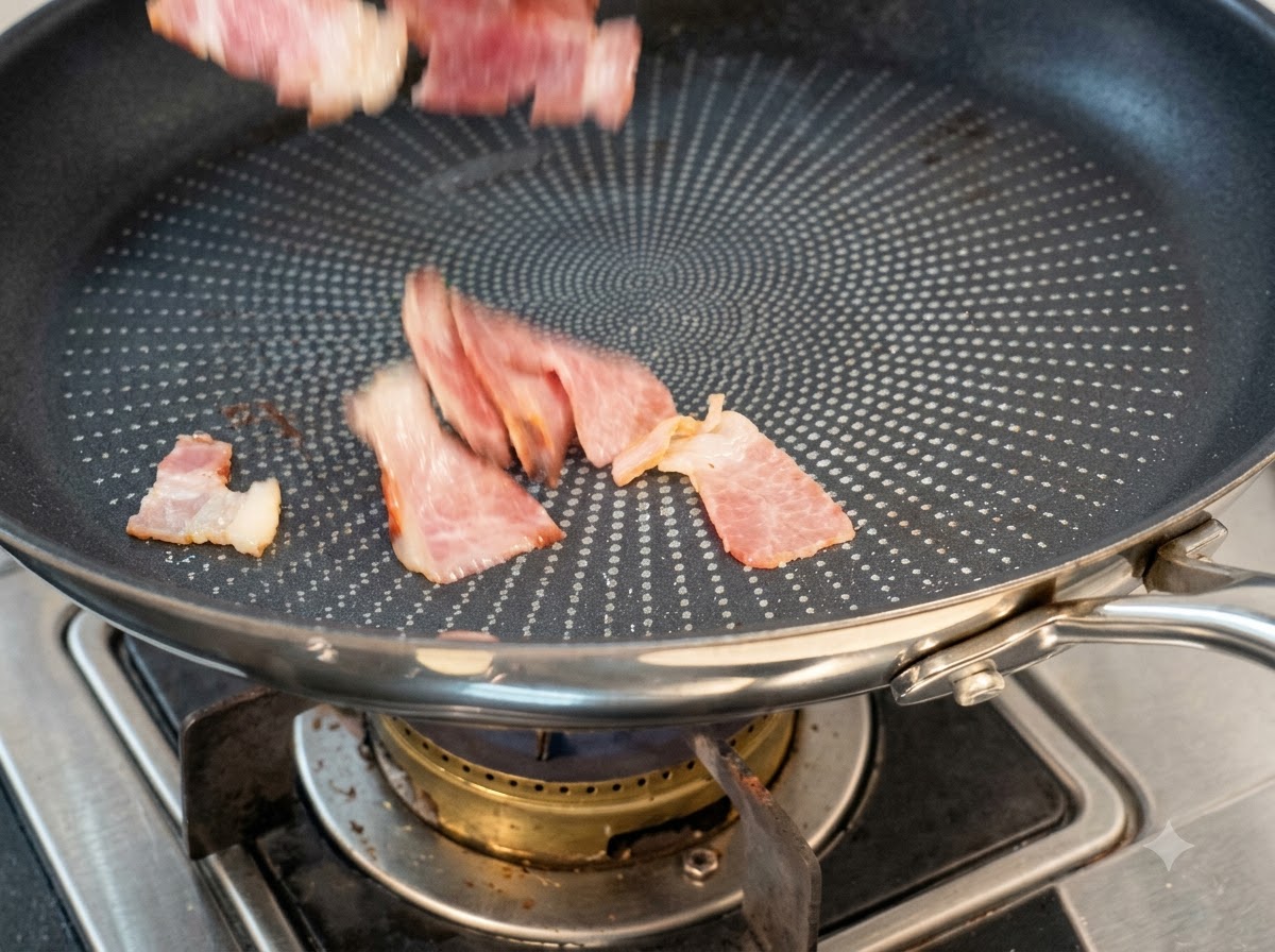 Trozos de tocino cortado cayendo en una sartén antiadherente seca para cocinar.