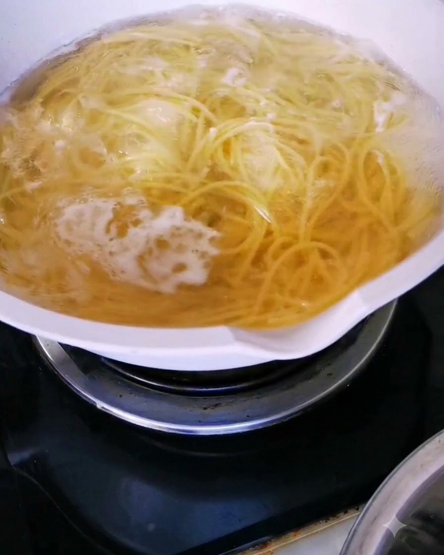 Fideos de espagueti hirviendo activamente en una olla de agua caliente.