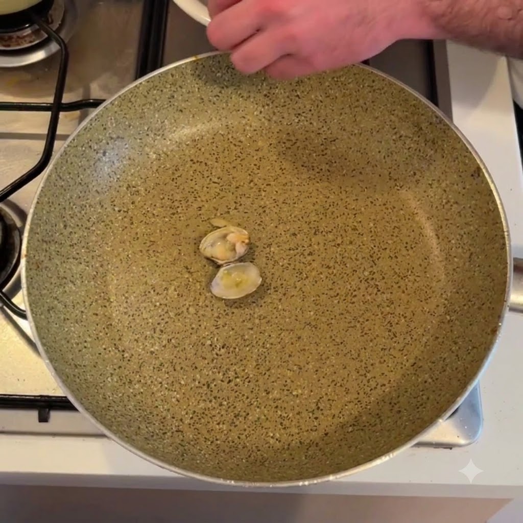 Carne de almeja extraída de su concha sobre una sartén.