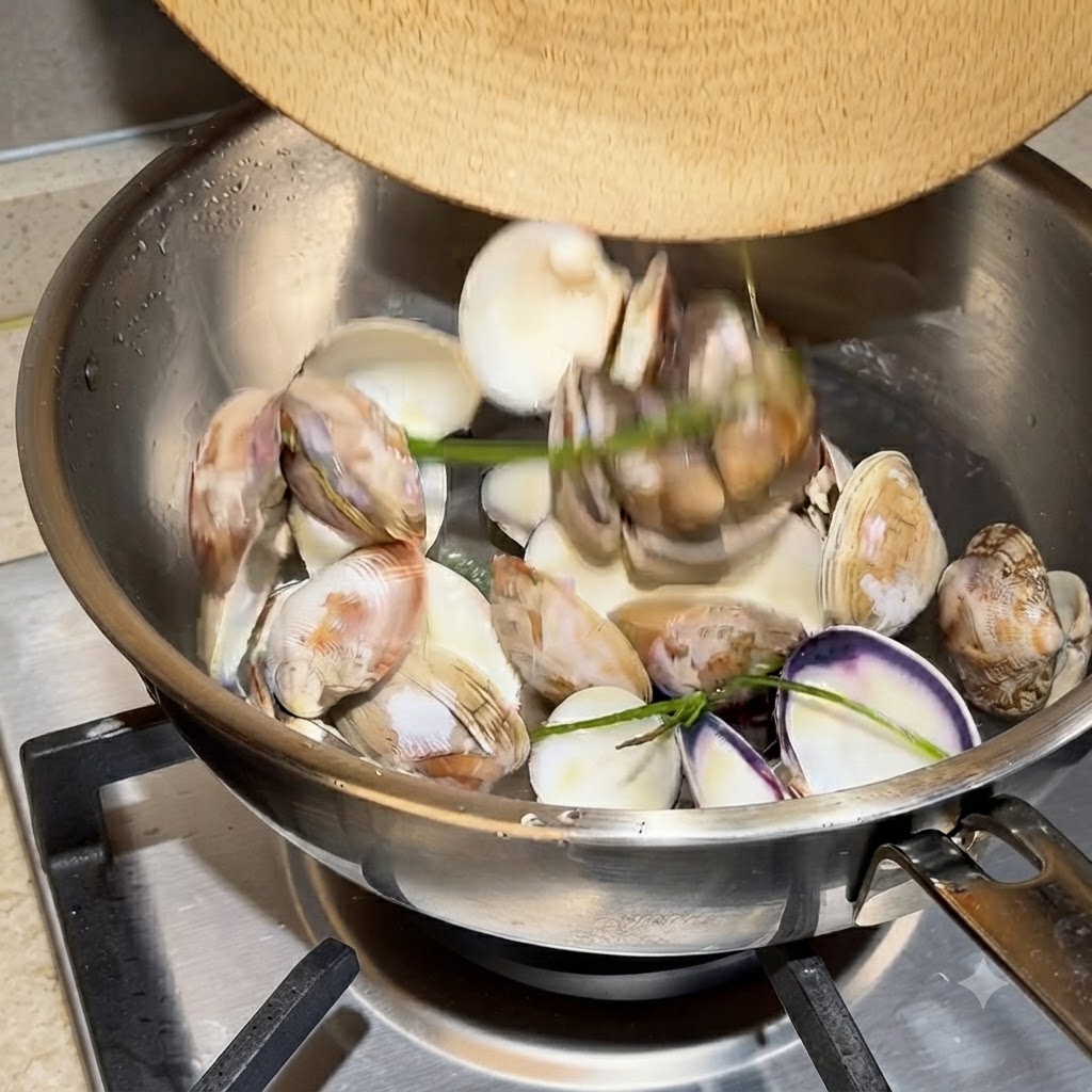 Conchas de almeja vacías y agua hirviendo vigorosamente en una olla de acero inoxidable.