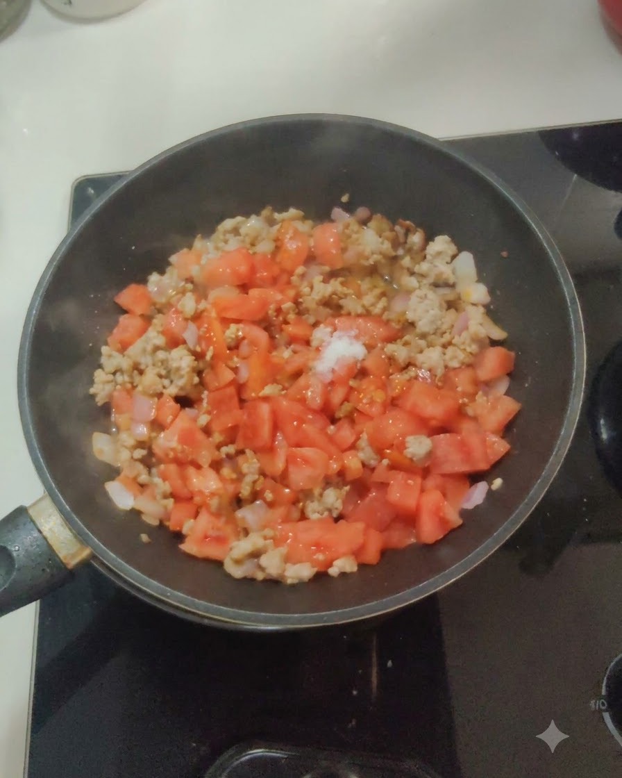 Sal blanca y azúcar espolvoreadas sobre la mezcla de tomate, cebolla y carne en la sartén.