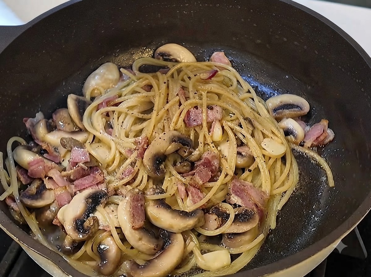 Salsa de trufa negra y pimienta negra recién molida incorporándose en la sartén de la pasta.