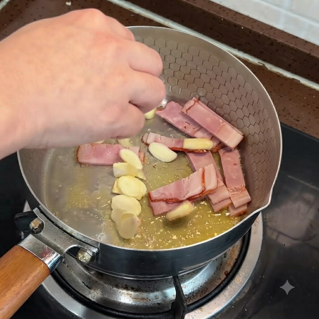 Tiras de tocino y trozos de ajo friéndose en una sartén con mantequilla derretida.