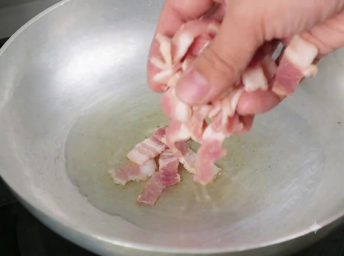 Trozos de tocino cayendo en una sartén con aceite de oliva caliente.