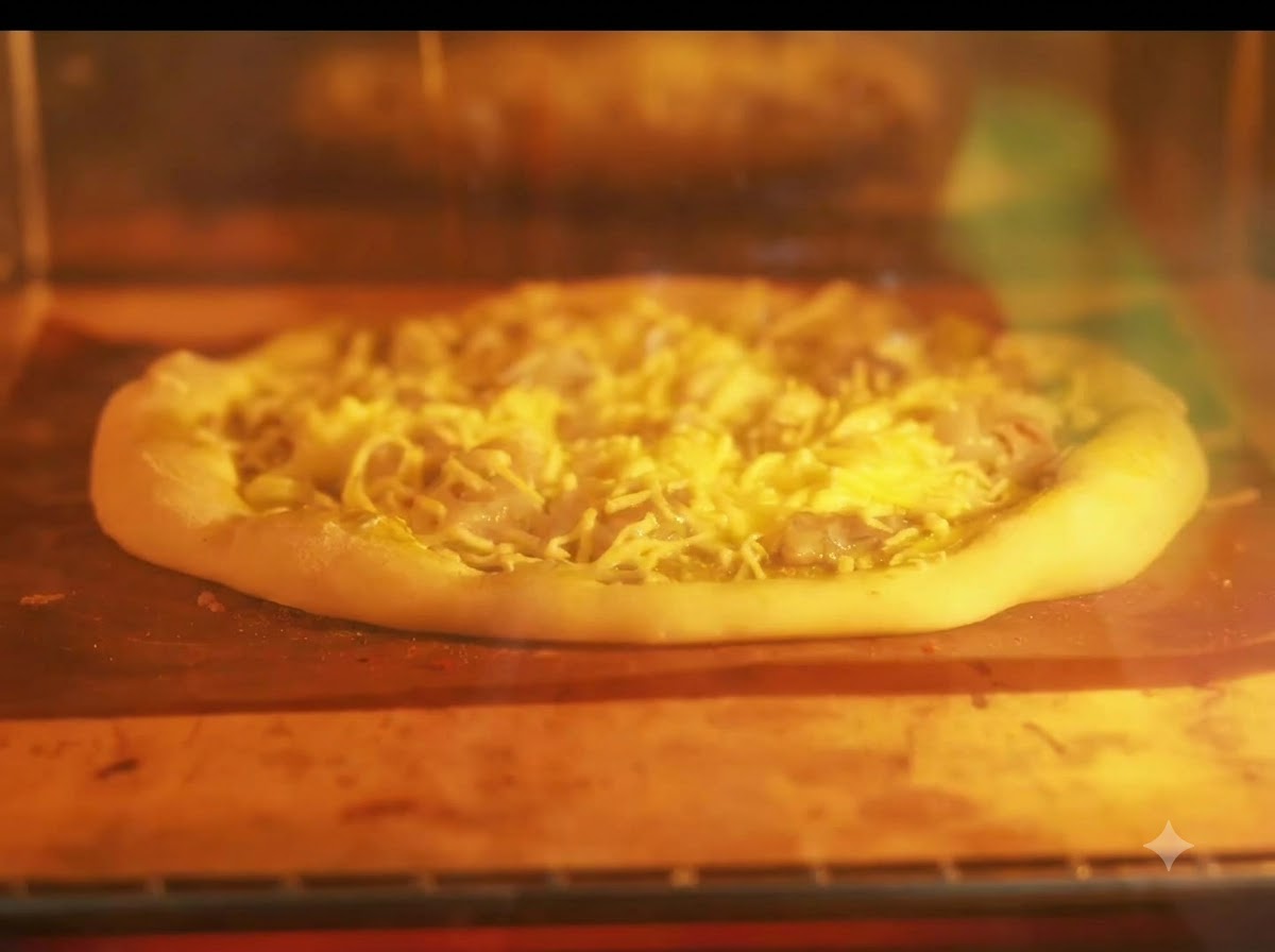 Una pizza horneándose en una bandeja dentro de un horno iluminado con las resistencias al rojo vivo.