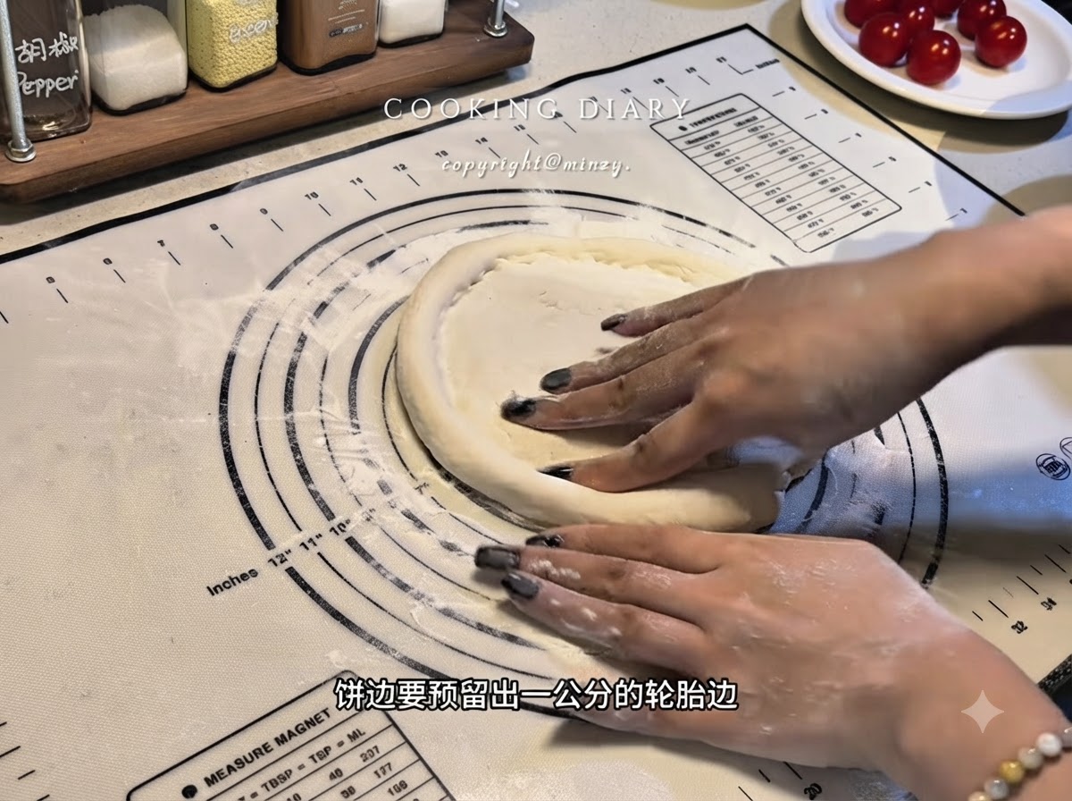 Manos dando forma a los bordes de la base de la masa de pizza plana en un tapete de silicona para formar un borde elevado.