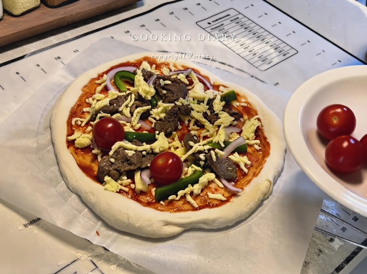 Una pizza completamente montada con queso, ternera, pimientos, cebollas y tomates cherry enteros sobre papel pergamino.