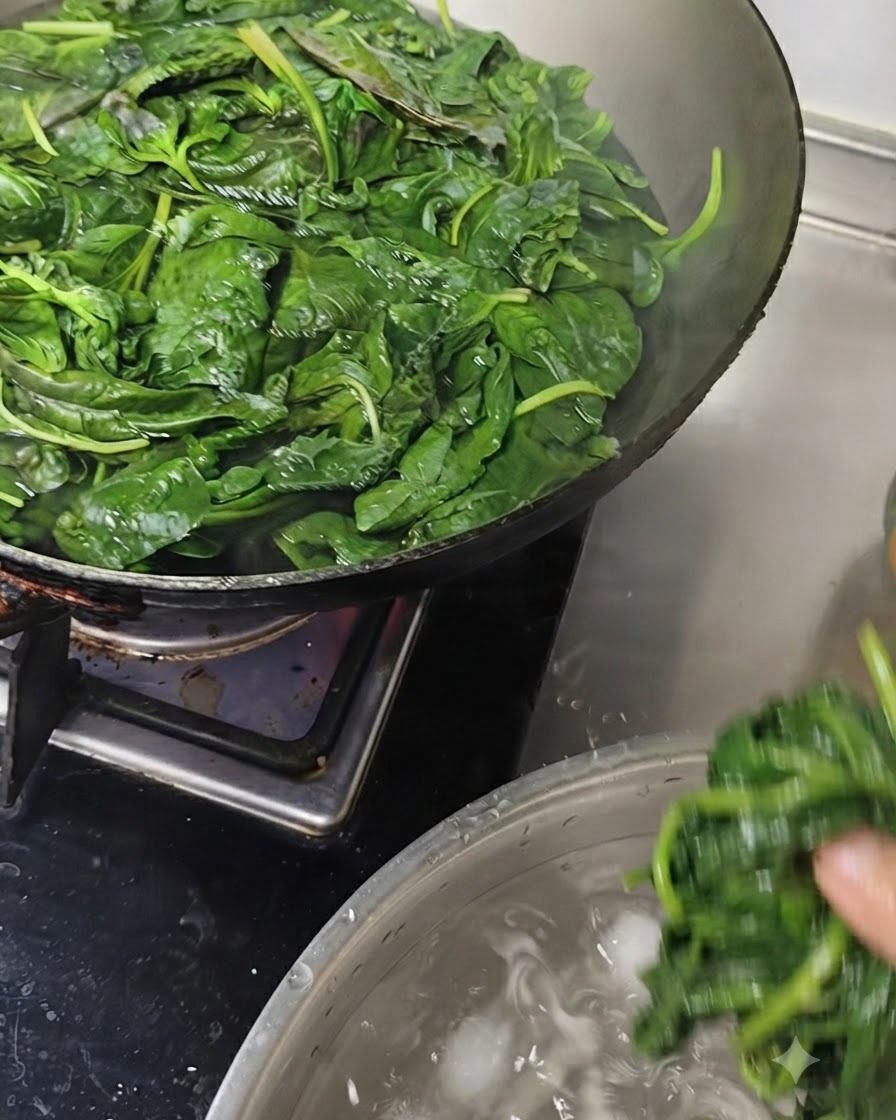 Hojas de albahaca siendo sumergidas en un tazón de agua fría con cubitos de hielo.