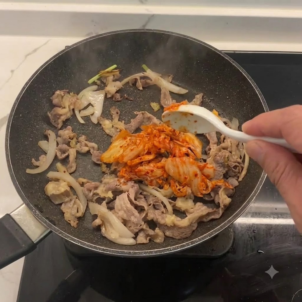 Kimchi picado siendo incorporado a la sartén con ternera y cebollas.