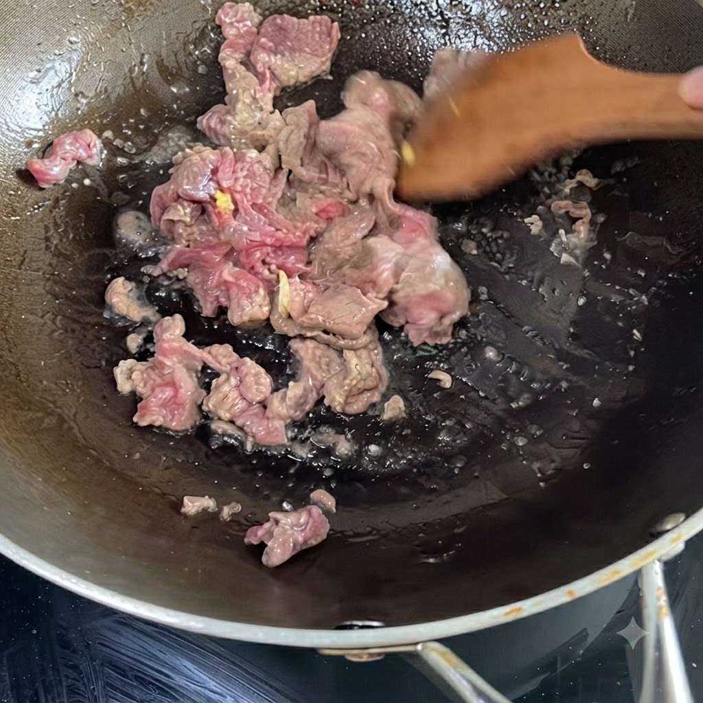 Ternera marinada cociéndose y salteándose en un wok caliente usando una espátula de madera.
