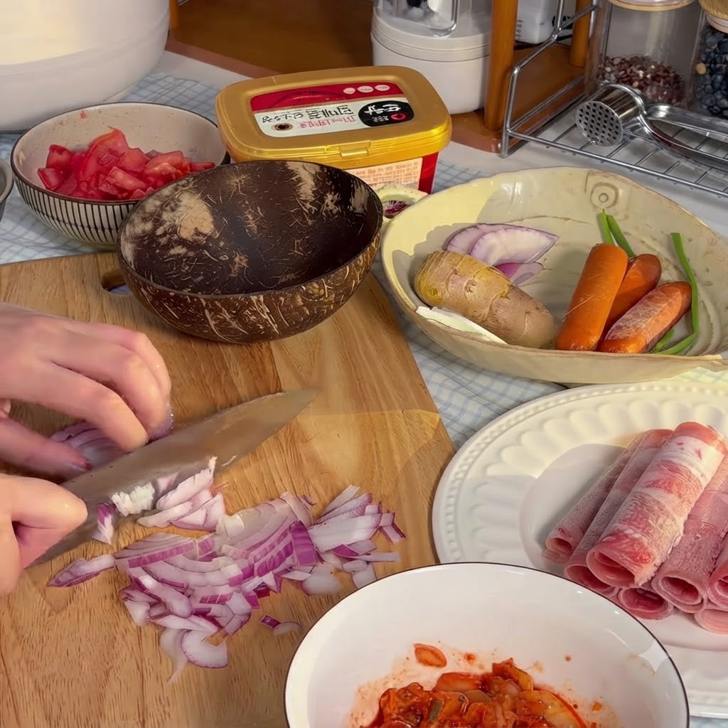 Cebolla roja siendo finamente picada en trozos pequeños sobre una tabla de cortar de madera.