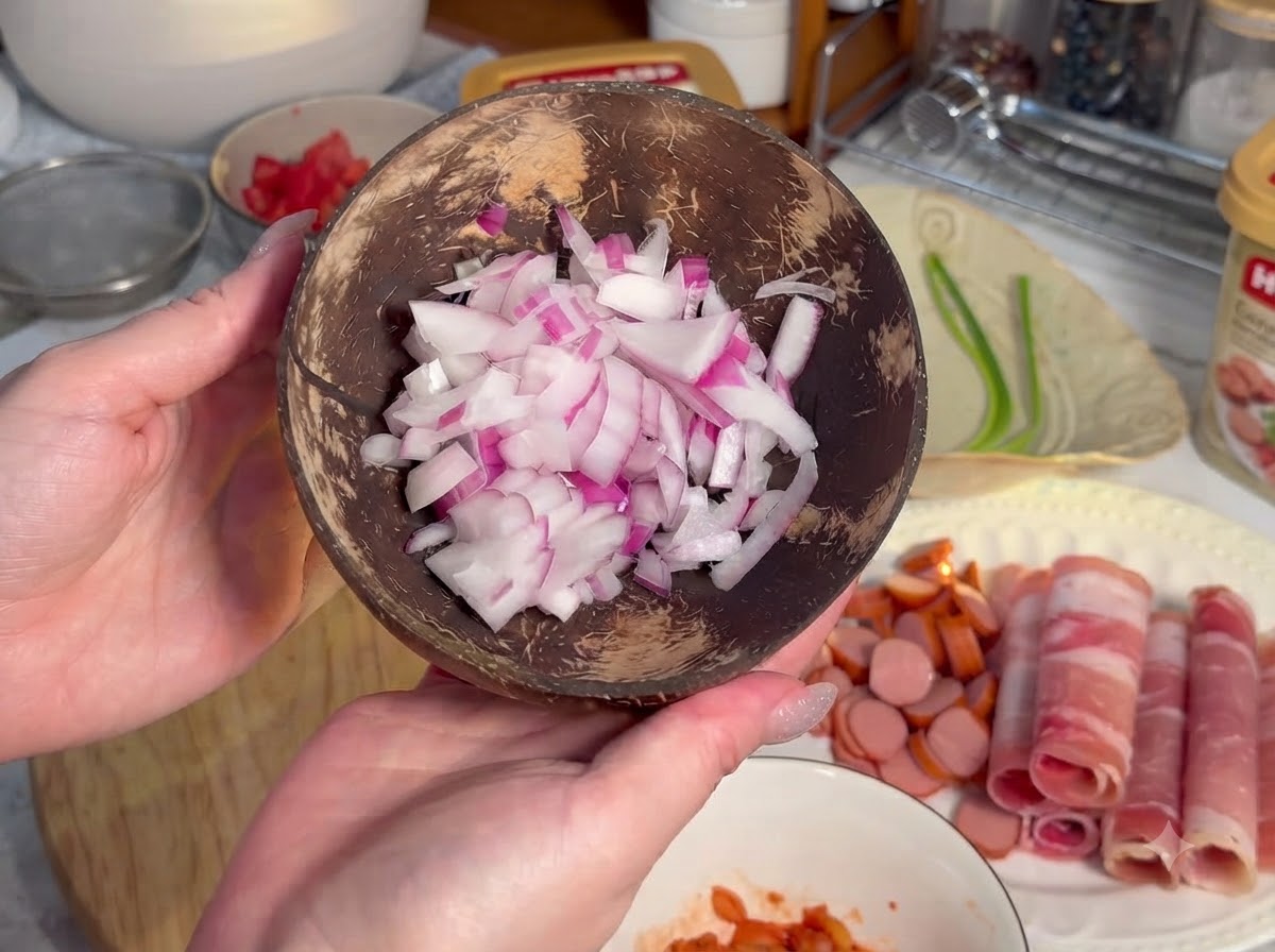 Salchichas cortadas en rodajas circulares pequeñas dispuestas en una tabla de madera junto a carne enrollada.