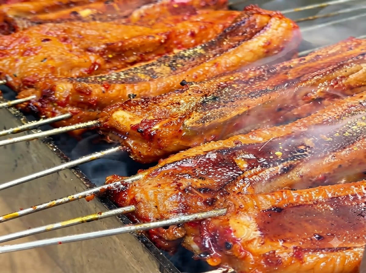 Polvo de especias amarillas siendo espolvoreado sobre las costillas a la parrilla.