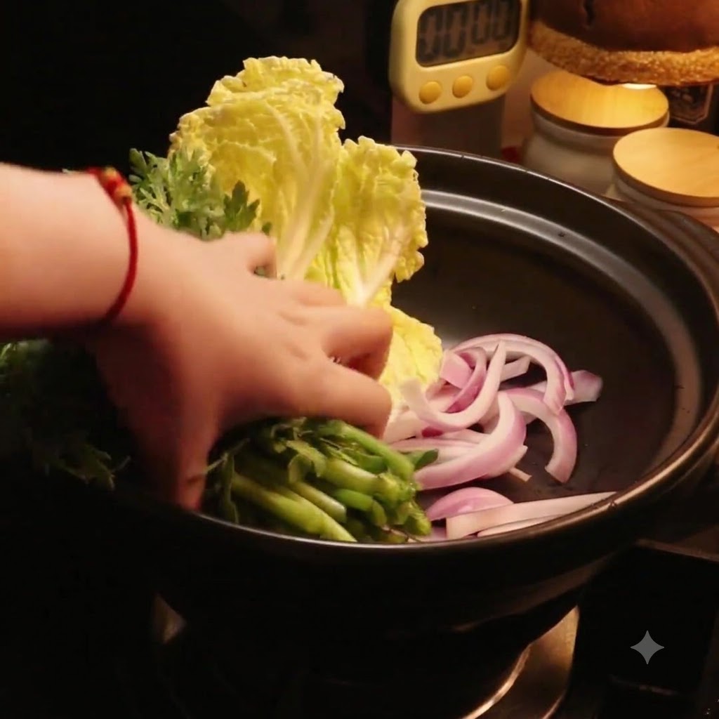 Una mano colocando verduras verdes frescas en la olla junto a la col.