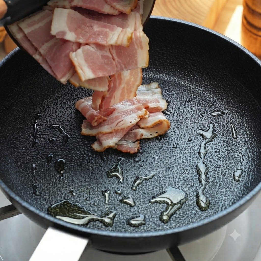 Tiras de tocino vertidas y cocinándose en una sartén aceitada.