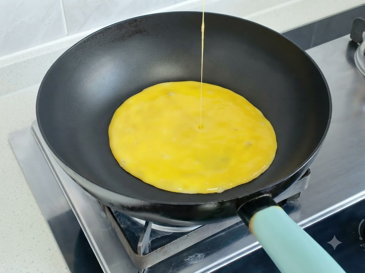 Mezcla de huevo batido siendo vertida en una sartén caliente para formar una tortilla.