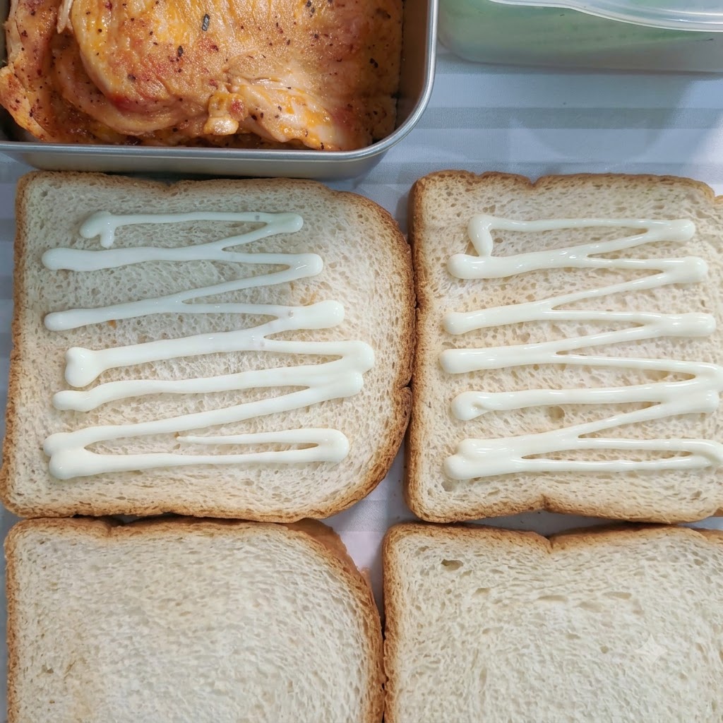 Aderezo de ensalada dulce rociado en líneas a través de cuatro rebanadas de pan blanco.