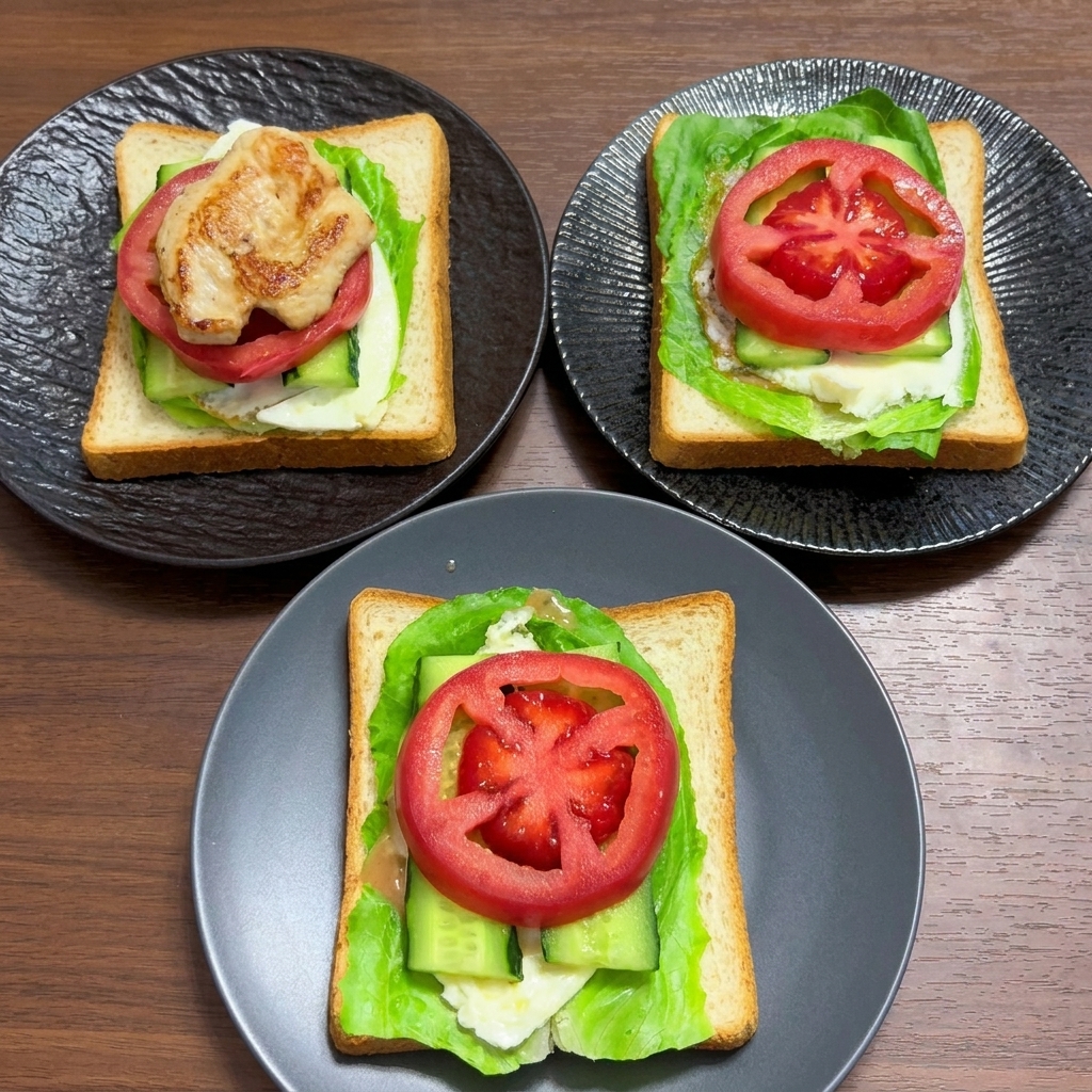 Capas de pan integral cubiertas con lechuga, huevo, pepino y rodajas gruesas de tomate fresco.