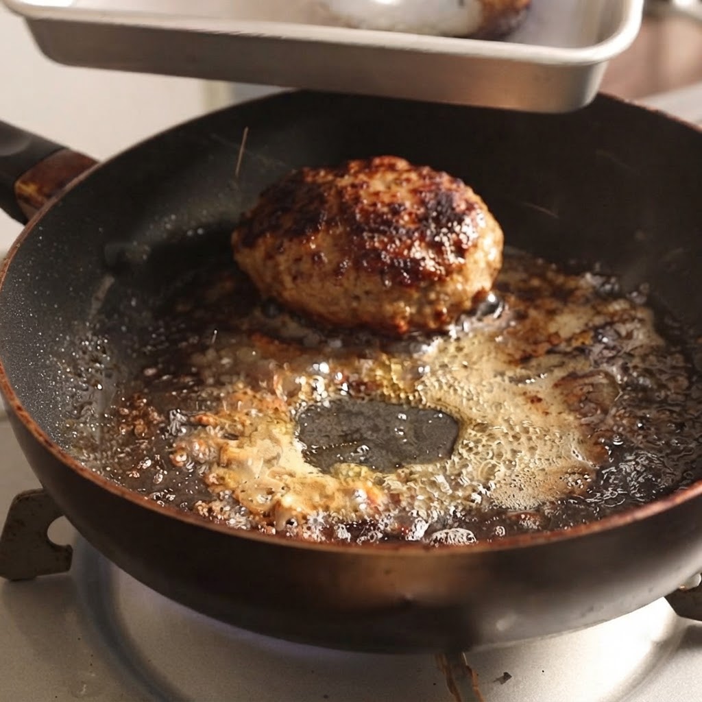 Hamburguesas retirándose de una sartén caliente usando pinzas de metal.