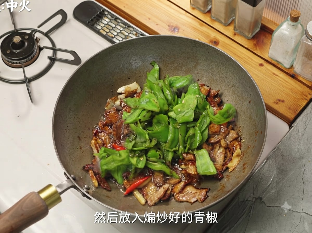 Pimientos verdes y setas siendo añadidos al wok con el cerdo condimentado.