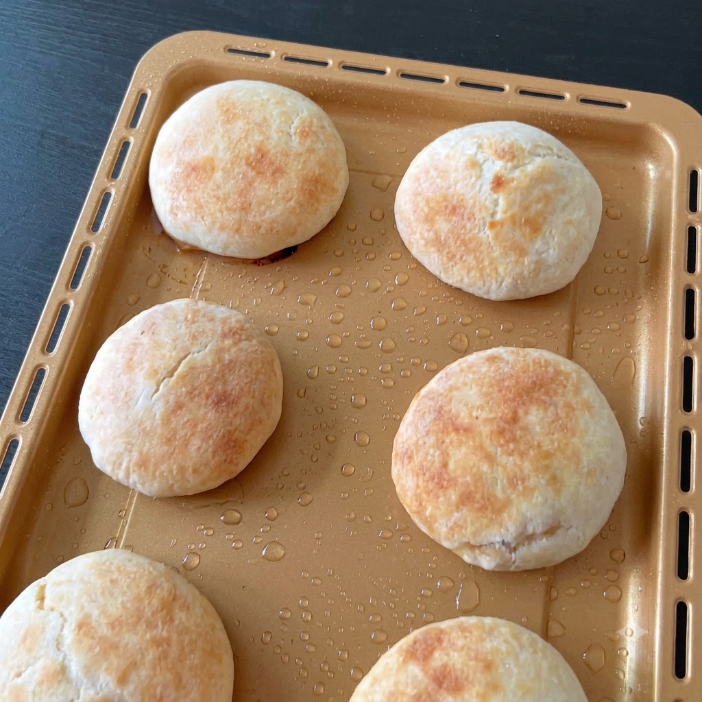 Rollo de masa enrollada siendo cortado en porciones iguales usando un raspador de banco.