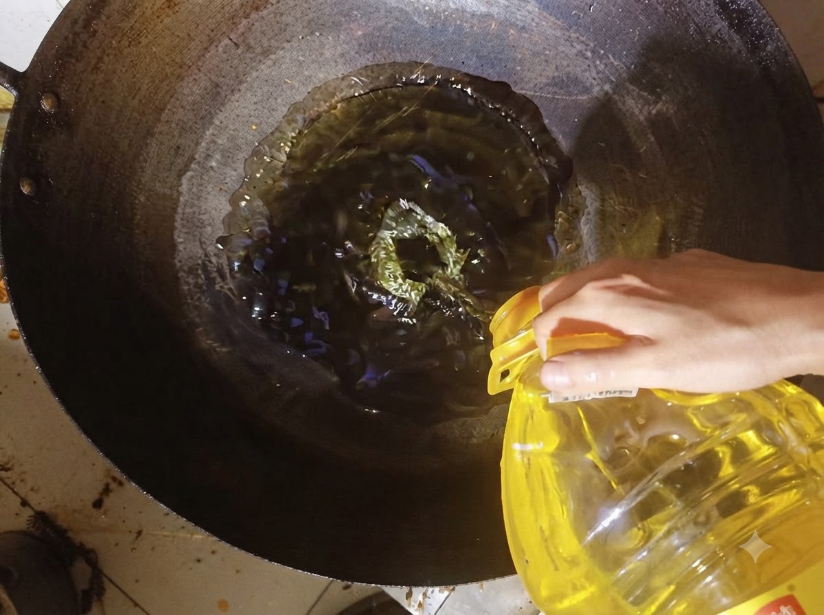 Aceite de cocina vertiéndose desde un recipiente hacia un wok caliente.