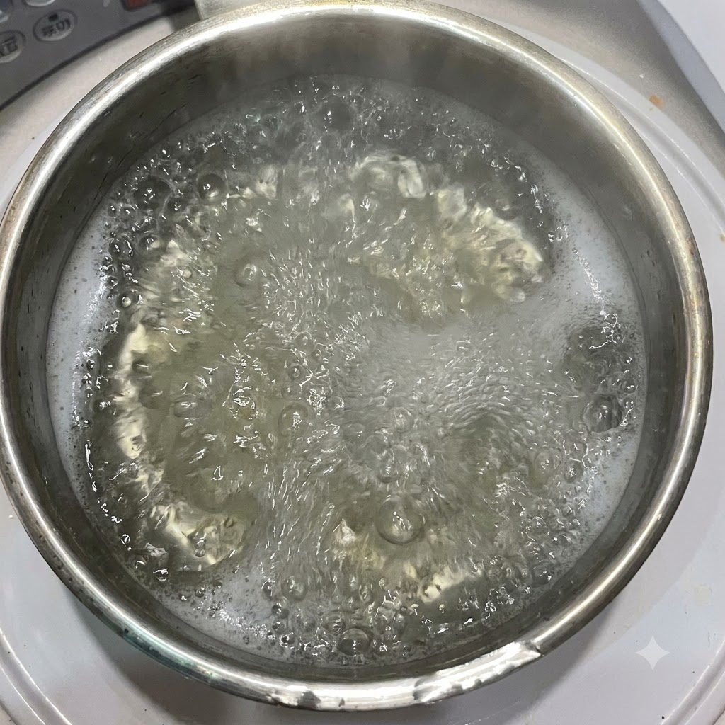 Aceite de oliva siendo vertido en una olla de agua hirviendo que contiene pasta penne.