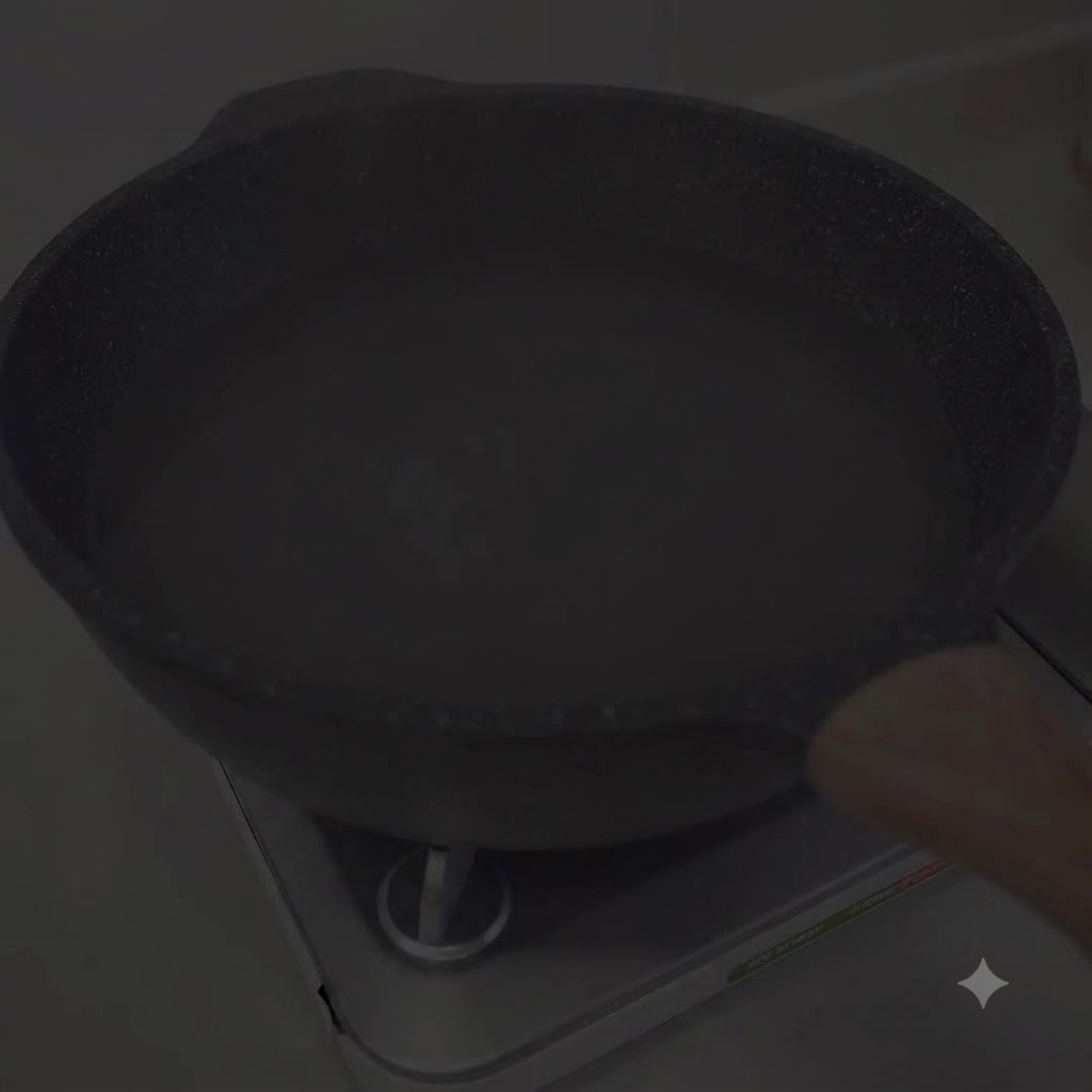 Una olla con agua calentándose en el quemador de una estufa.