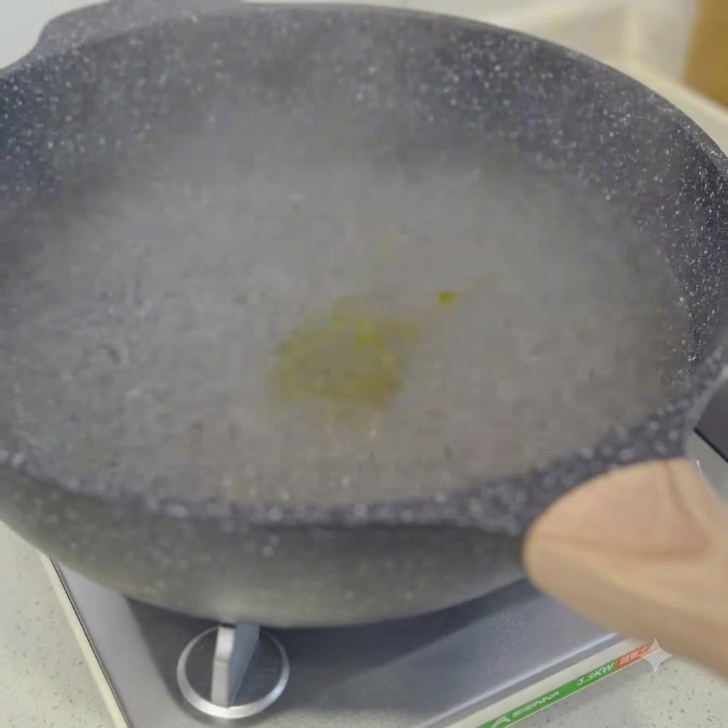 Espaguetis cocinándose en una olla con agua hirviendo siendo revueltos con palillos.