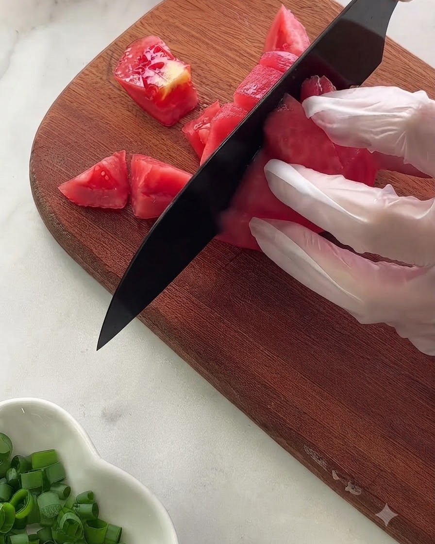 Una vista de cerca de varios ingredientes y condimentos de la salsa medidos dentro de un tazón de vidrio sobre un paño de lunares.