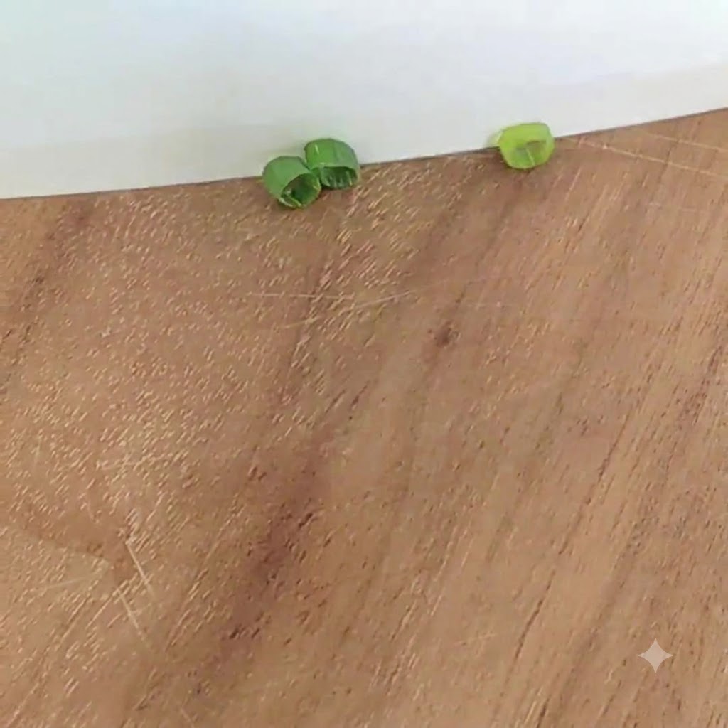 Rodajas de cebolla verde en una tabla de cortar de madera.