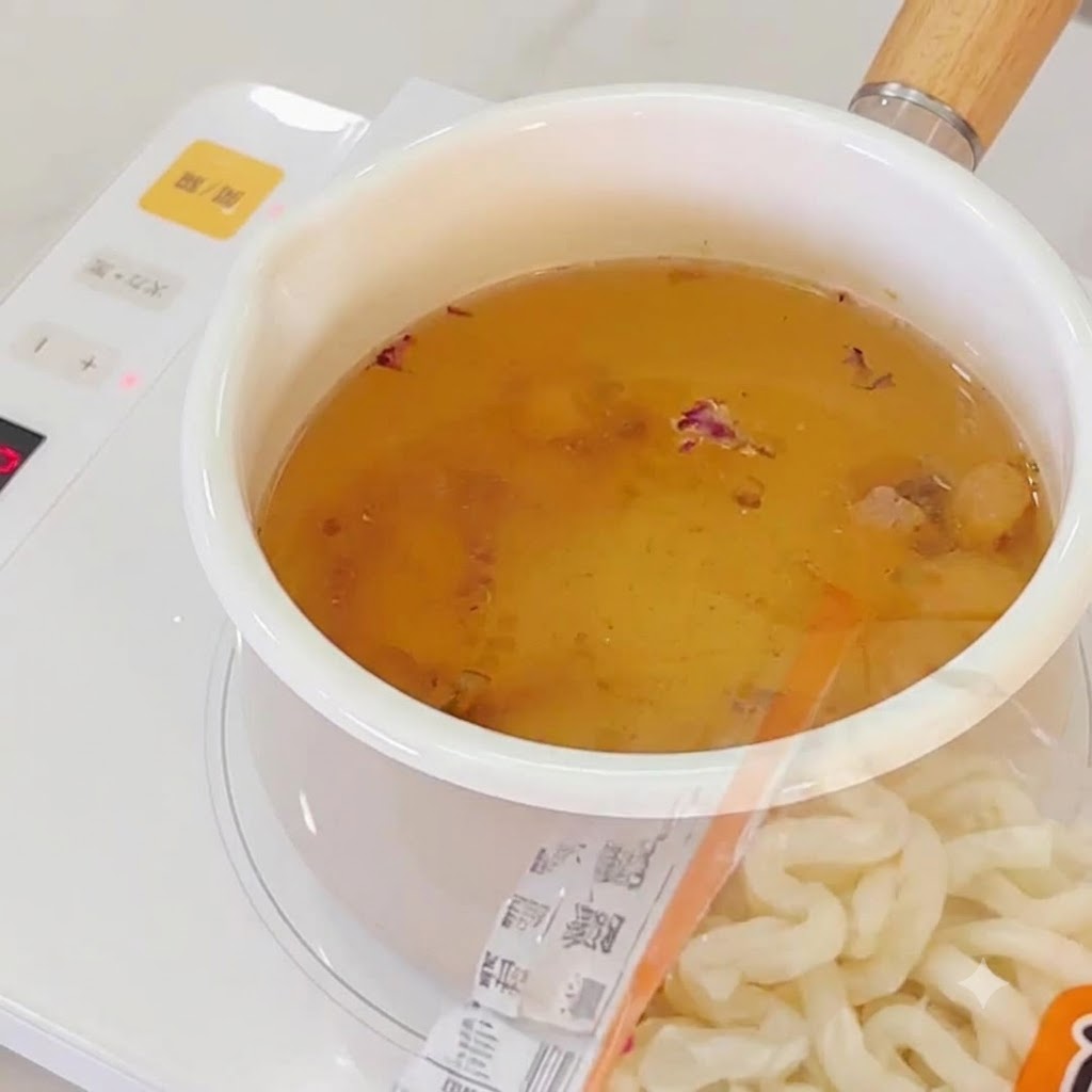 Fideos de ramen siendo añadidos al caldo de ajo hirviendo.
