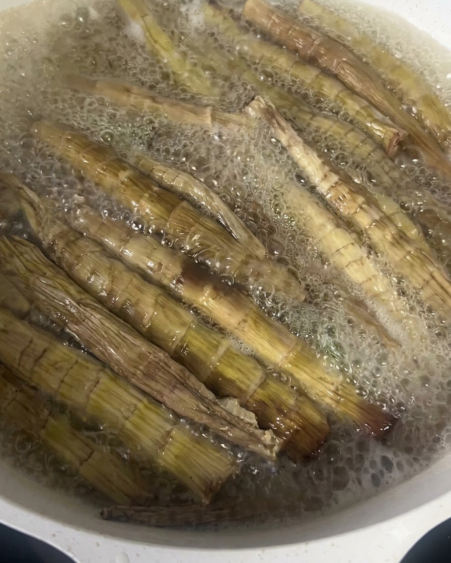 Brotes de bambú secos hirviendo vigorosamente en una olla con agua caliente.