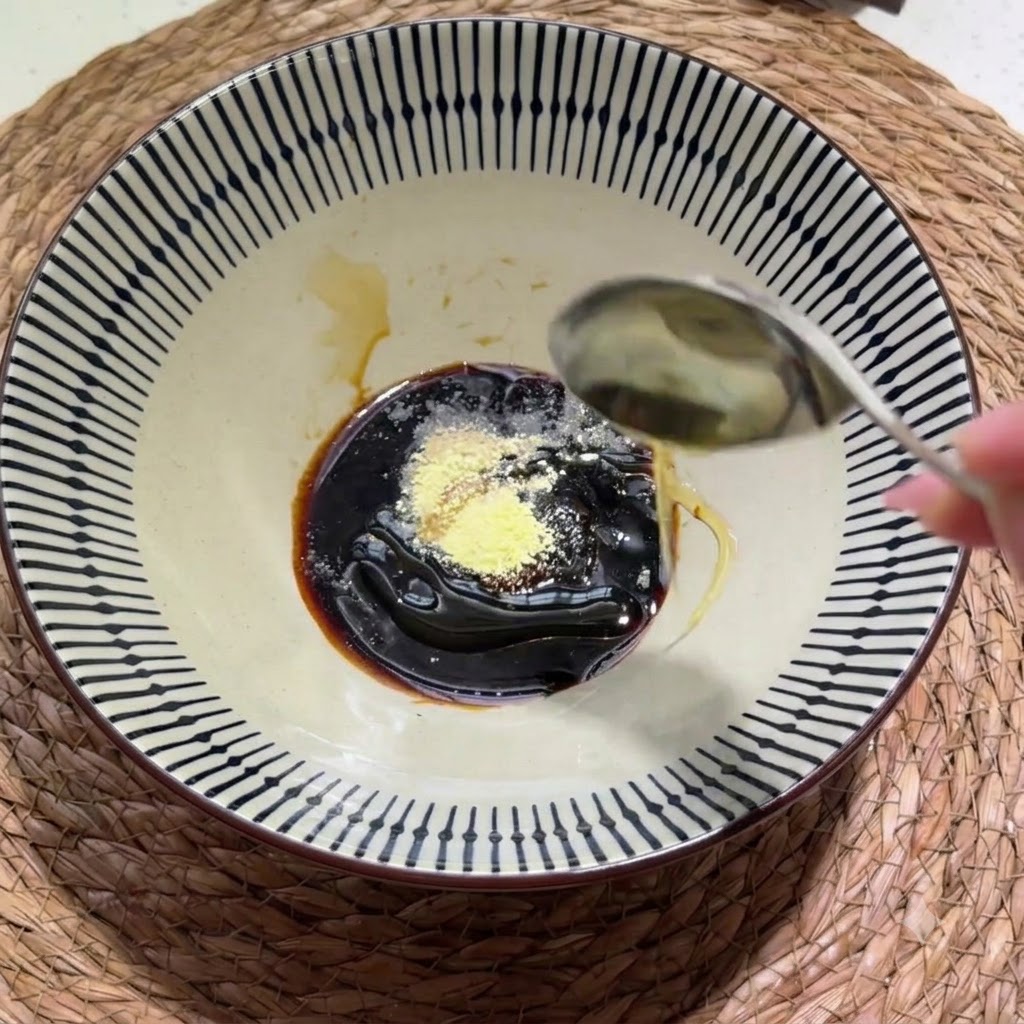 Espesa pasta de sésamo y cacahuete y un chorrito de aceite de sésamo siendo añadidos al cuenco de condimentos.