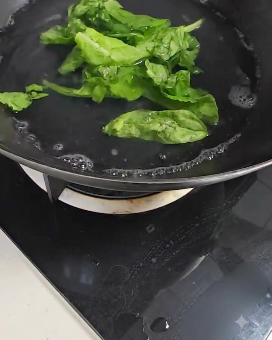 Hojas frescas de bok choy verde hirviendo en una olla con agua burbujeante sobre una estufa.