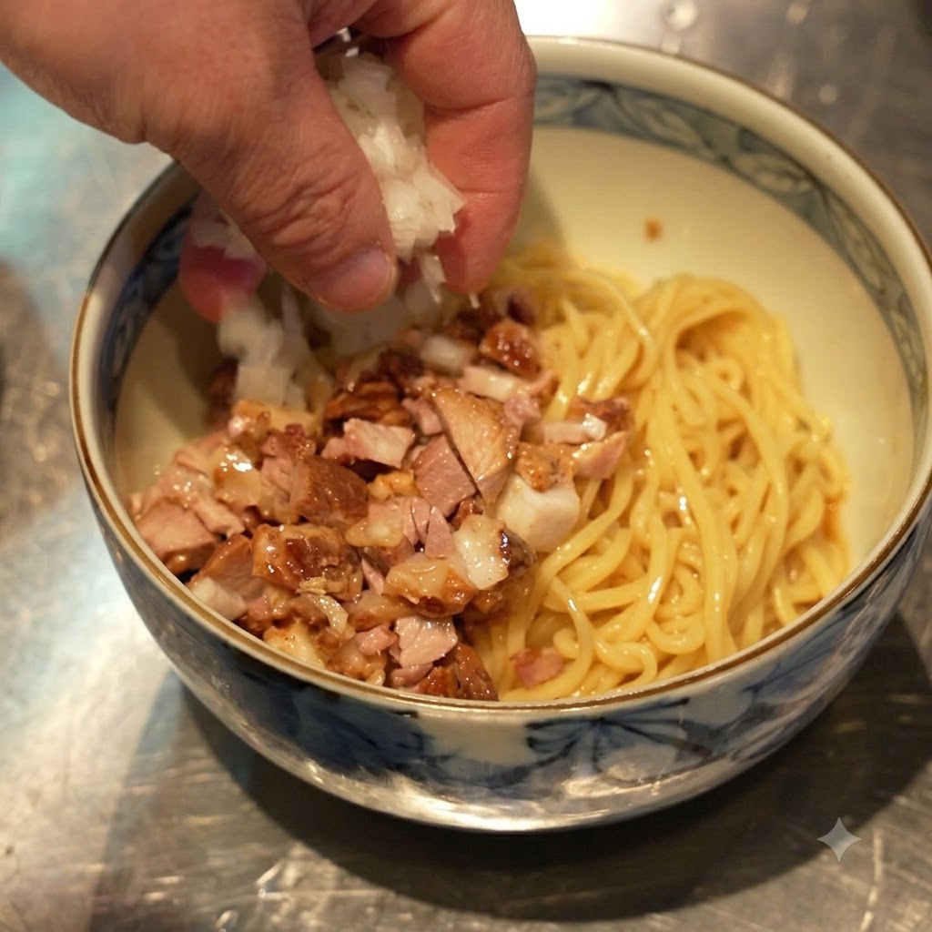 Mano esparciendo cebollas blancas picadas en el tazón que contiene fideos y chashu en dados.