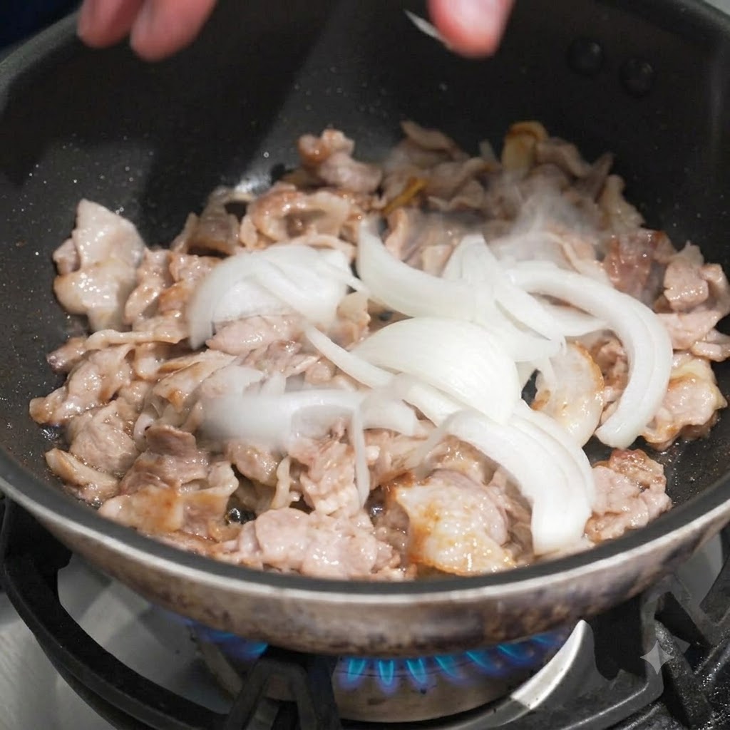 Cebollas blancas en rodajas siendo añadidas a mano en una sartén con cerdo cocinado en rodajas.