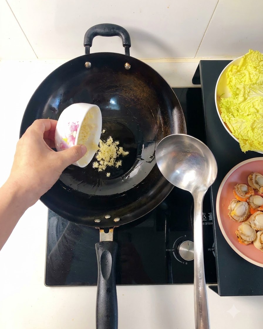 Ajo picado friéndose en aceite caliente dentro de un wok, dorándose y desprendiendo aroma.