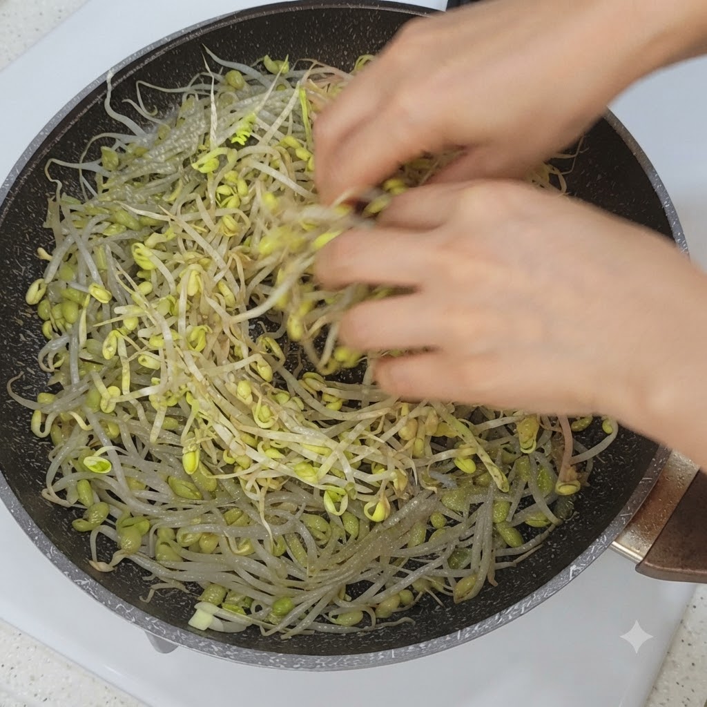Verduras y rodajas de panceta organizándose encima de los brotes de soja en una sartén.