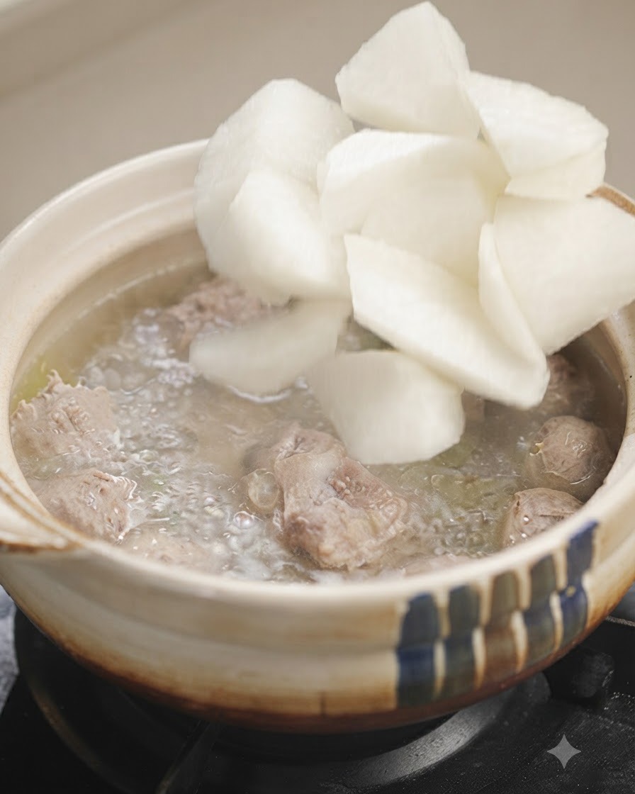 Trozos de rábano blanco siendo añadidos a una olla de sopa burbujeante.