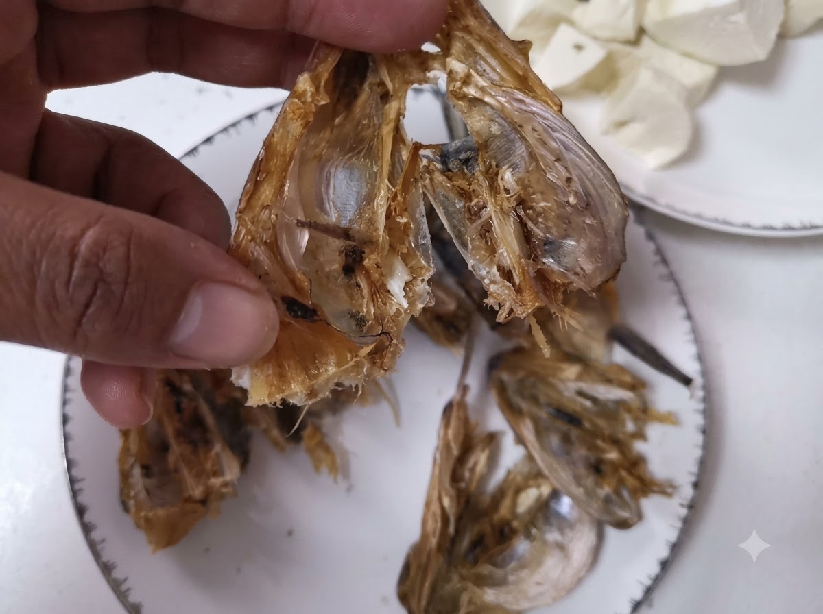 Vista de cerca de las cabezas de pescado seco siendo abiertas y limpiadas con un cuchillo.