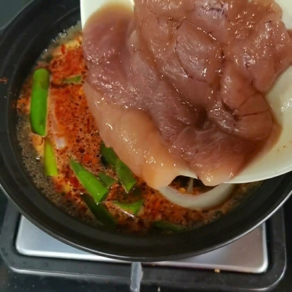 Trozos frescos de huevas de abadejo transfiriéndose de un plato a una olla de sopa a fuego lento con verduras verdescite: 1.