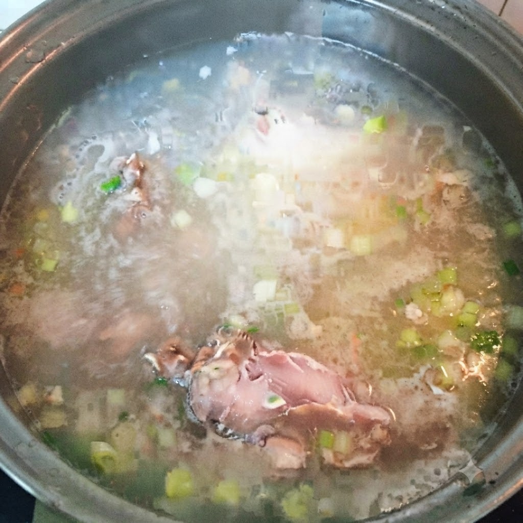Trozos de pescado restantes siendo añadidos al caldo de sopa hirviendo.