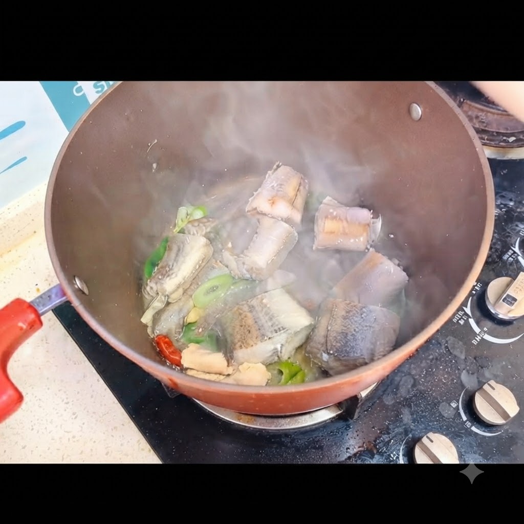 Agua hirviendo siendo vertida sobre los trozos de pescado dentro de una olla en la estufa.