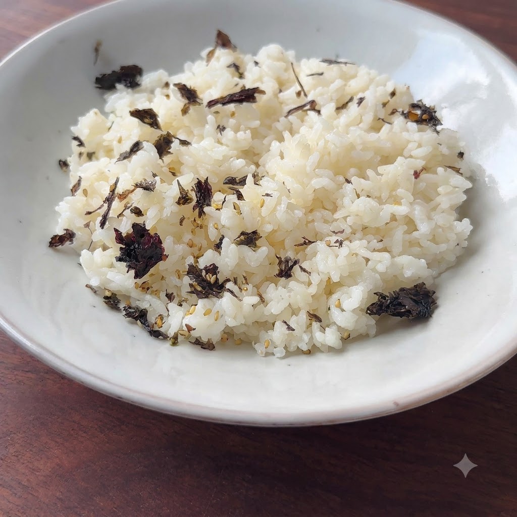 Arroz sazonado adornado con copos oscuros en un tazón blanco, listo para el armado.
