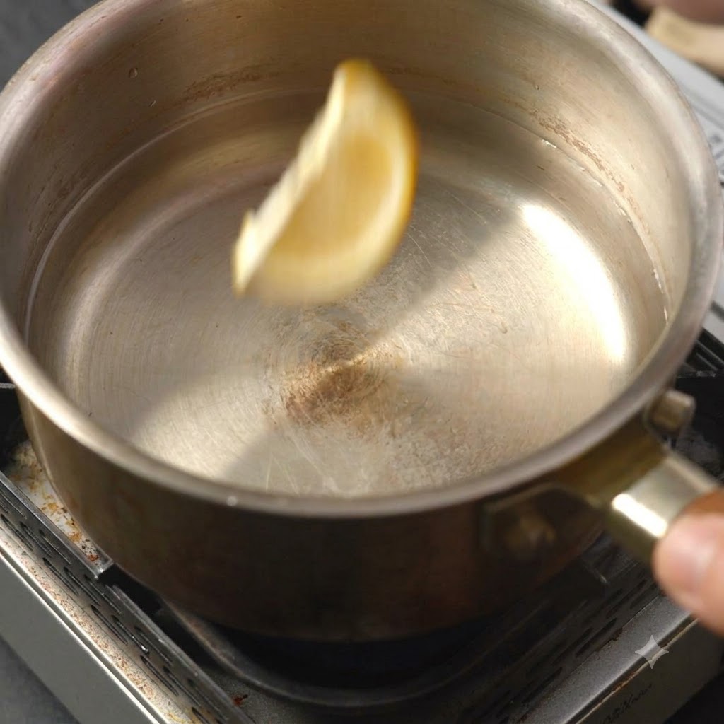 Una rodaja de limón cayendo en la olla con líquido.