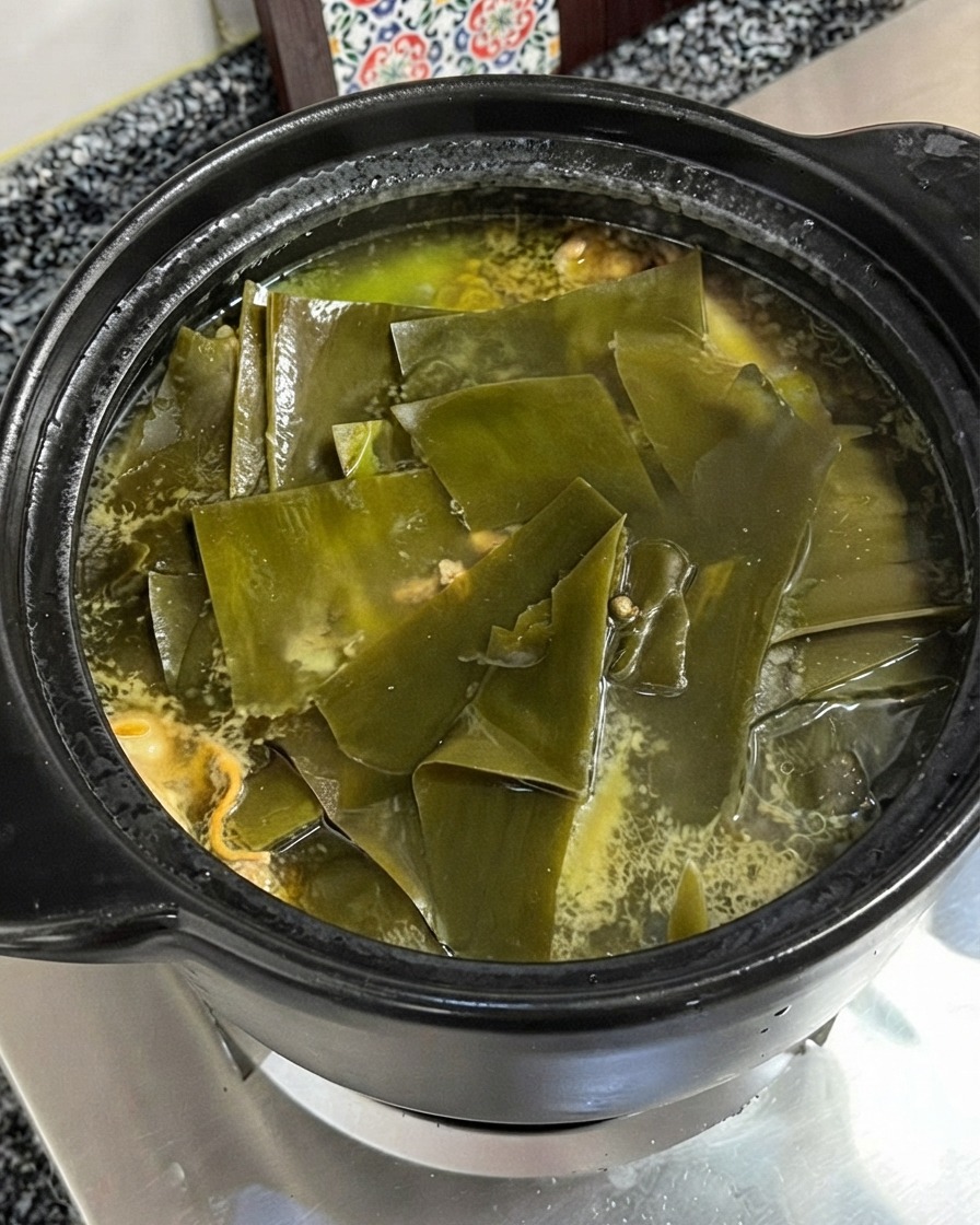 Polvo de esencia de pollo cayendo en la sopa hirviendo de pollo y alga kelp.