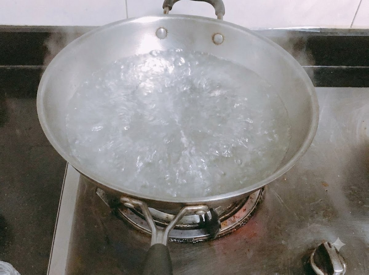 Fideos de pasta largos cociéndose en una olla con agua hirviendo con sal.