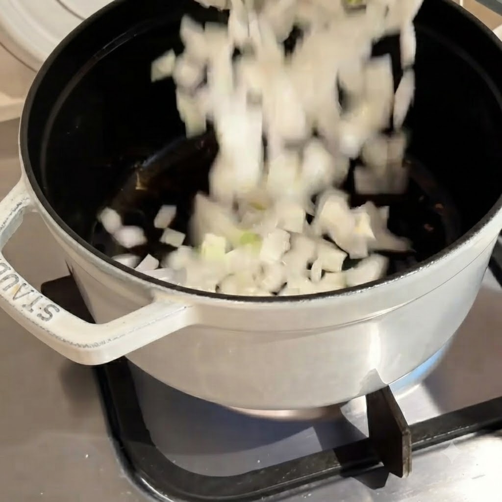Cebollas blancas picadas cayendo en una olla caliente durante el proceso de cocción.