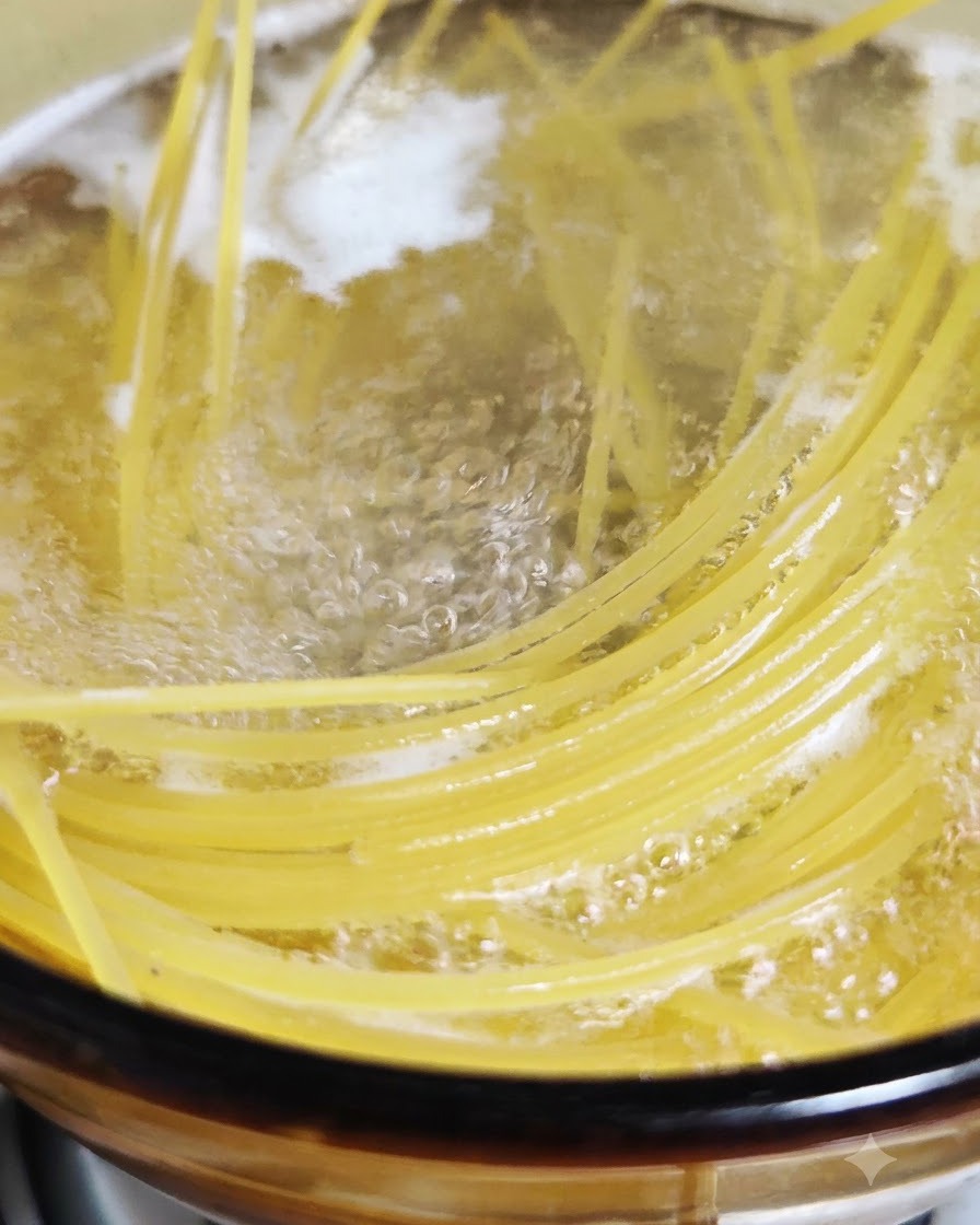 Fideos de espagueti cocinándose y burbujeando en una olla con agua hirviendo con sal.